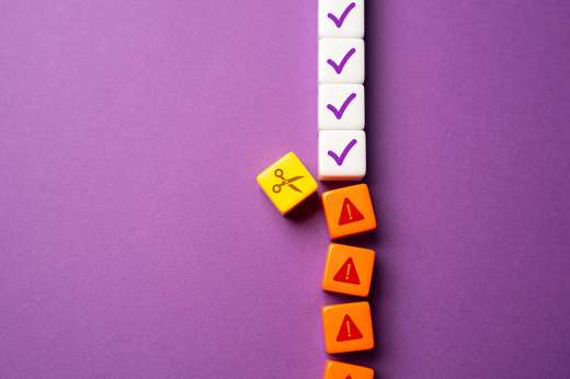 Foto: Reihe aus Würfeln wird mit Schere durchtrennt